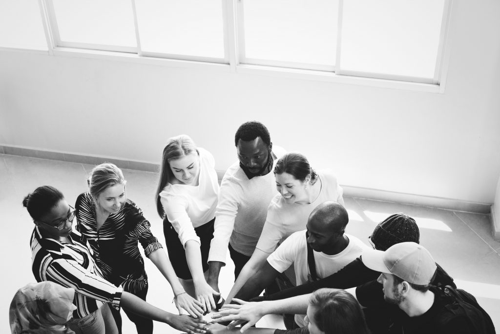 people putting their hands in the middle of a huddle